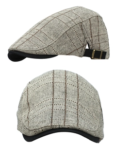 Detail of adjustable metal buckle and vintage plaid texture on British flat cap