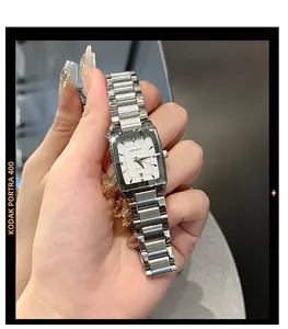 Macro detail of square quartz watch with silver steel strap and date window