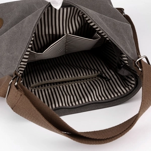 Deep grey canvas crossbody bag featuring brown straps and striped interior lining detail