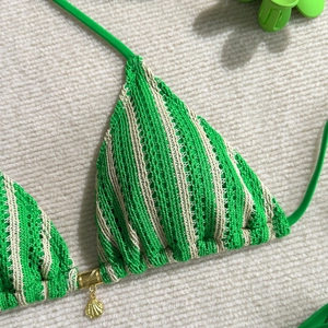 Détail du haut de bikini au crochet à rayures vertes avec pendentif coquillage doré