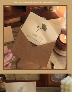 Detail of vintage kraft envelope with ginkgo leaf card and decorative wax seal sticker