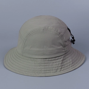 Gros plan du tissu mesh léger à séchage rapide et de la poche zippée sur le chapeau gris