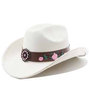 Detail of white cowboy hat featuring vintage floral embroidery and bronze flower buckle