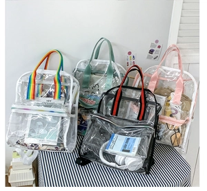 Detailed view of large transparent PVC backpacks with colorful straps on a striped background