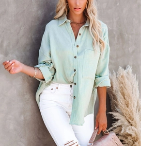Detail of mint green cotton linen shirt featuring button-down collar and textured fabric