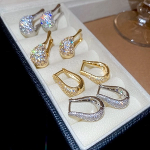 Détails de boucles d'oreilles en forme de U dorées et argentées avec zircons en coffret