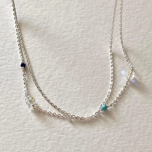 Macro shot of silver 925 sterling chain with faceted blue and clear zircon beads