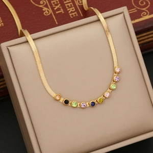 Detail of gold snake chain necklace with colorful round crystals on a jewelry box