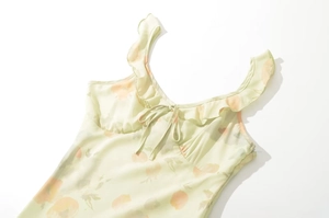 Détail de l'encolure à volants et du cordon sur une robe longue à fleurs jaune clair