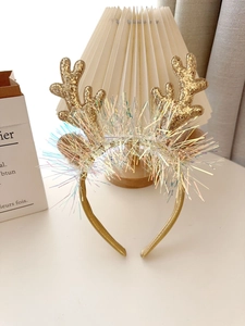 Detailed view of Christmas reindeer antler headband with gold glitter and colorful tinsel