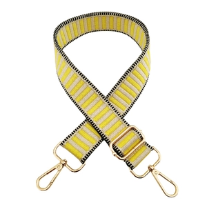 Close-up of adjustable yellow striped bag strap with gold metal hooks and hardware