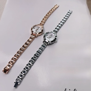 Detail of rose gold and silver quartz watches with Roman numeral dials on a magazine