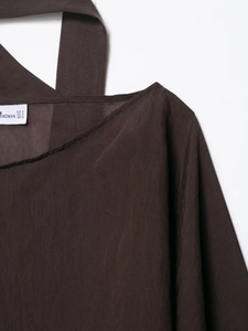 Detail shot of a dark brown silk blouse collar with size labels and premium stitching