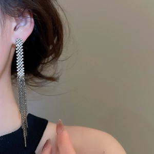 Close-up of elegant long silver tassel earrings with shimmering rhinestone embellishments