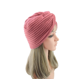 Detailed texture of dusty rose knit beanie featuring a vintage twist knot design