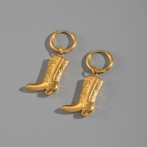 Detailed close-up of golden stainless steel earrings featuring cowboy boot pendant charms