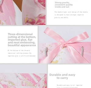 Detail view of pink marble gift bag with reinforced satin handles and gold foil texture