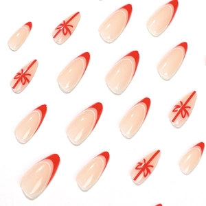 Mandelförmige Kunstnägel mit roten French Tips und festlichen Schleifen-Designs