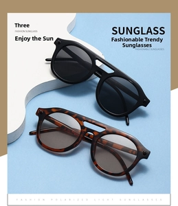 Detail view of round double-bridge sunglasses in black and tortoiseshell acetate finish