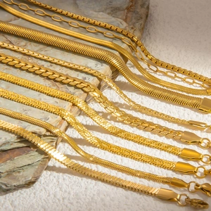 Macro view of assorted 18k gold snake and curb chains on stone texture