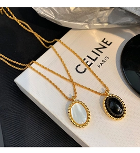 Detail of vintage oval pendants with white mother of pearl and black onyx in gold twisted frames