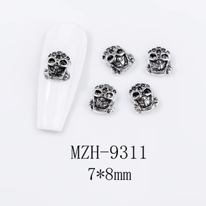 Detailed macro view of 3D skull nail charms in silver-black metal for Halloween DIY
