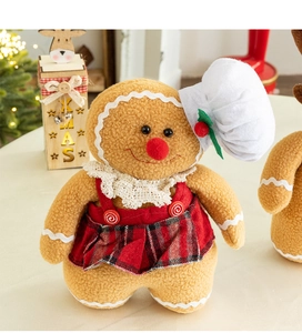 Close-up of plush gingerbread man gnome doll with red plaid skirt and white chef hat