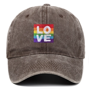 Close-up view of the rainbow LOVE embroidery on a distressed brown washed cotton baseball cap