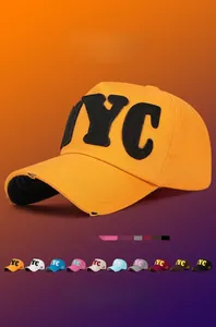 Detail of embroidered NYC patch on yellow cotton baseball cap with distressed brim