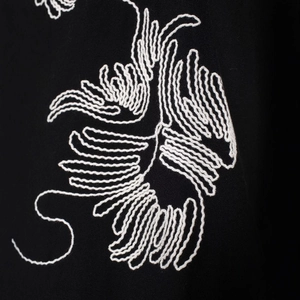 Short sleeve women's mock neck shirt with white zen-style floral embroidery on black fabric