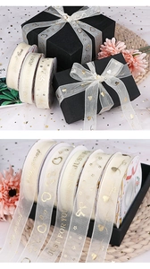 Detail of champagne chiffon ribbon with gold stamped heart and forever love patterns