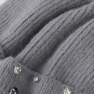 Macro detail of grey knit fabric with plush mohair texture and shimmering rhinestones