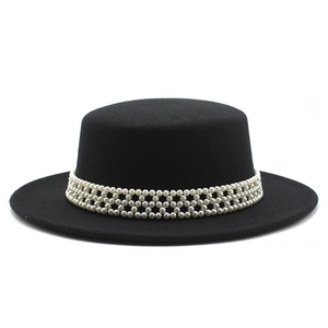 Detailed view of black flat boater hat with elegant white pearl decorative band