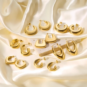 Various geometric 18k gold plated stainless steel hollow hoop earrings set on beige silk