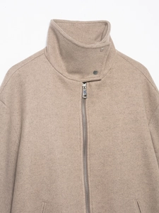 Detail view of camel wool bomber jacket featuring a stand collar and metal zipper texture