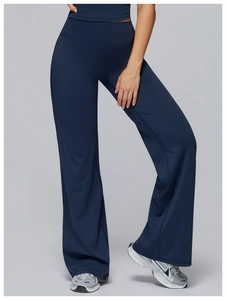 Detail of high-waisted navy blue yoga pants with a flared slit hem and elastic fabric