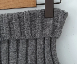 Detailed macro view of the ribbed knit waistband and soft wool texture of the grey mini skirt