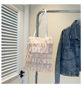 Detail of pink floral lace shoulder bag with layered ruffles and white thin straps