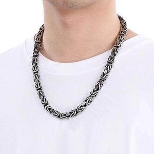 Men's silver Byzantine chain necklace in stainless steel worn on white t-shirt
