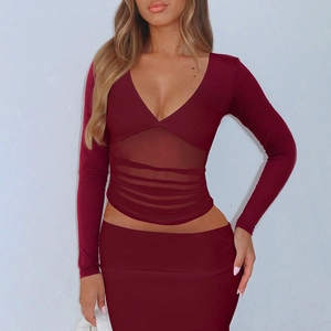Détail du haut bordeaux avec décolleté en V profond et empiècements en tulle à la taille