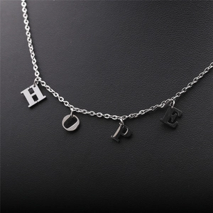 Vue détaillée du collier en acier inoxydable argenté avec pendentifs lettres HOPE