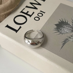 Minimalist chunky 925 sterling silver dome ring with polished finish on art book background