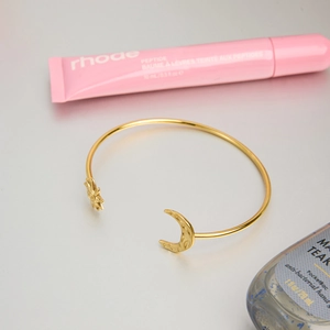 Détail du bracelet en acier plaqué or 18K avec extrémités gravées soleil et lune