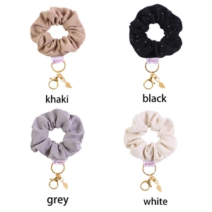 Detail of velvet rhinestone hair scrunchies with golden leaf charm in four elegant colors