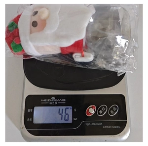 Detailed view of Santa themed candy jar showing lightweight 46g weight on digital scale