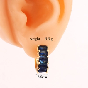 Detail of 6.5mm gold hoop earrings featuring five rectangular deep blue gemstones