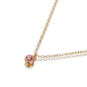 Gold plated stainless steel necklace with pink zircon round pendant on white background