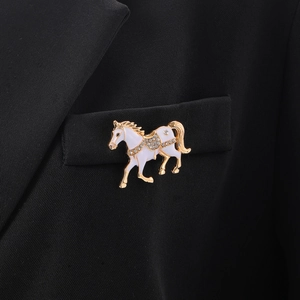 Detail der luxuriösen Pferde-Brosche mit Emaille und Strass auf schwarzer Anzugtasche