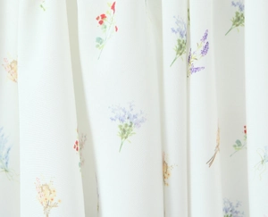 Dettaglio del tessuto con stampa floreale rossa e viola su materiale intrecciato bianco