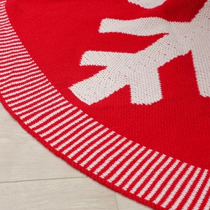Dettaglio del tappeto per albero di Natale in maglia rossa e bianca con fiocchi di neve